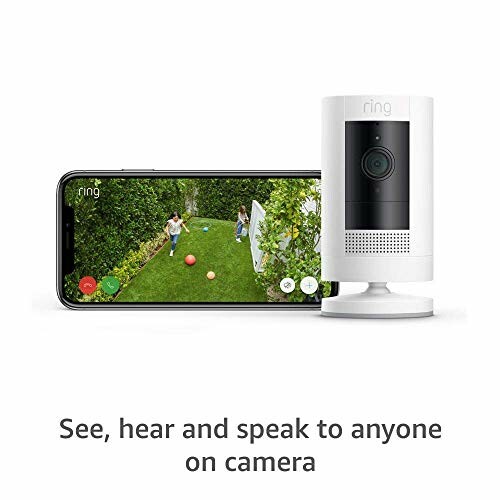 Ring security camera next to a smartphone displaying a garden view.