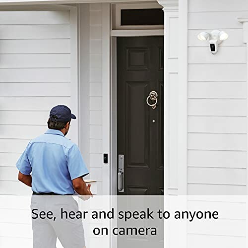 Person approaching a front door with a smart doorbell camera and light.