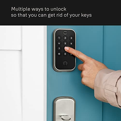 Person using keypad on smart lock door.